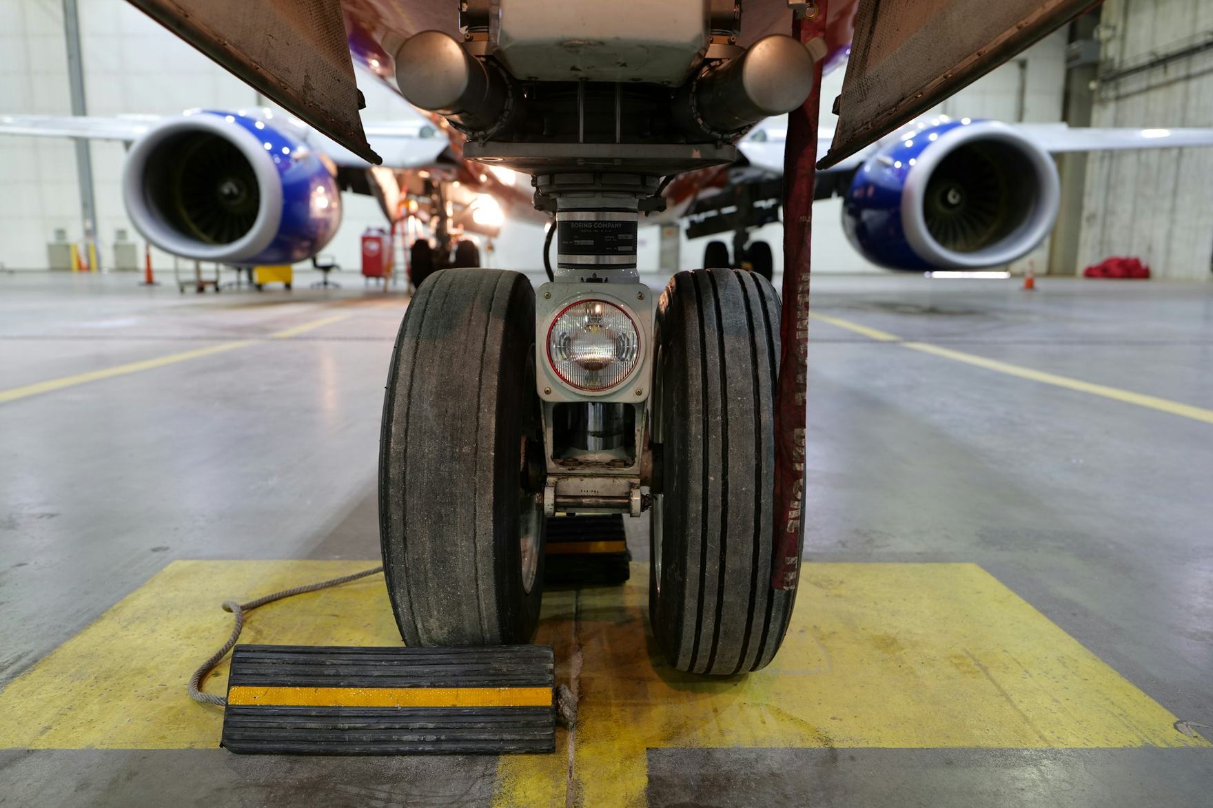 Main landing gear assembly of an airliner viewed from below inside a hangar